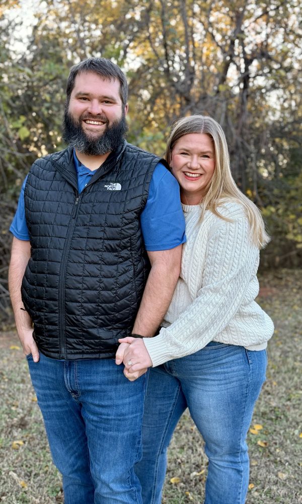 Tara and Tyler holding hands outdoors in the fall